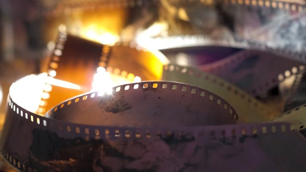 A curl of 35mm film strip lit from behind