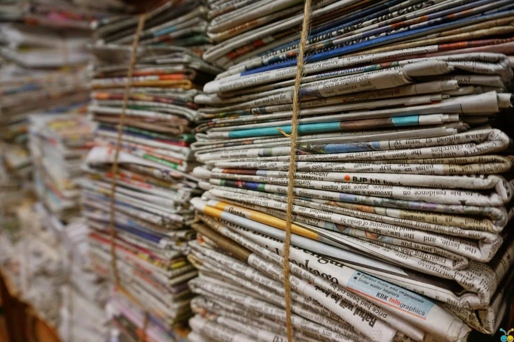 Bundled stacks of folded newspapers tied with twine